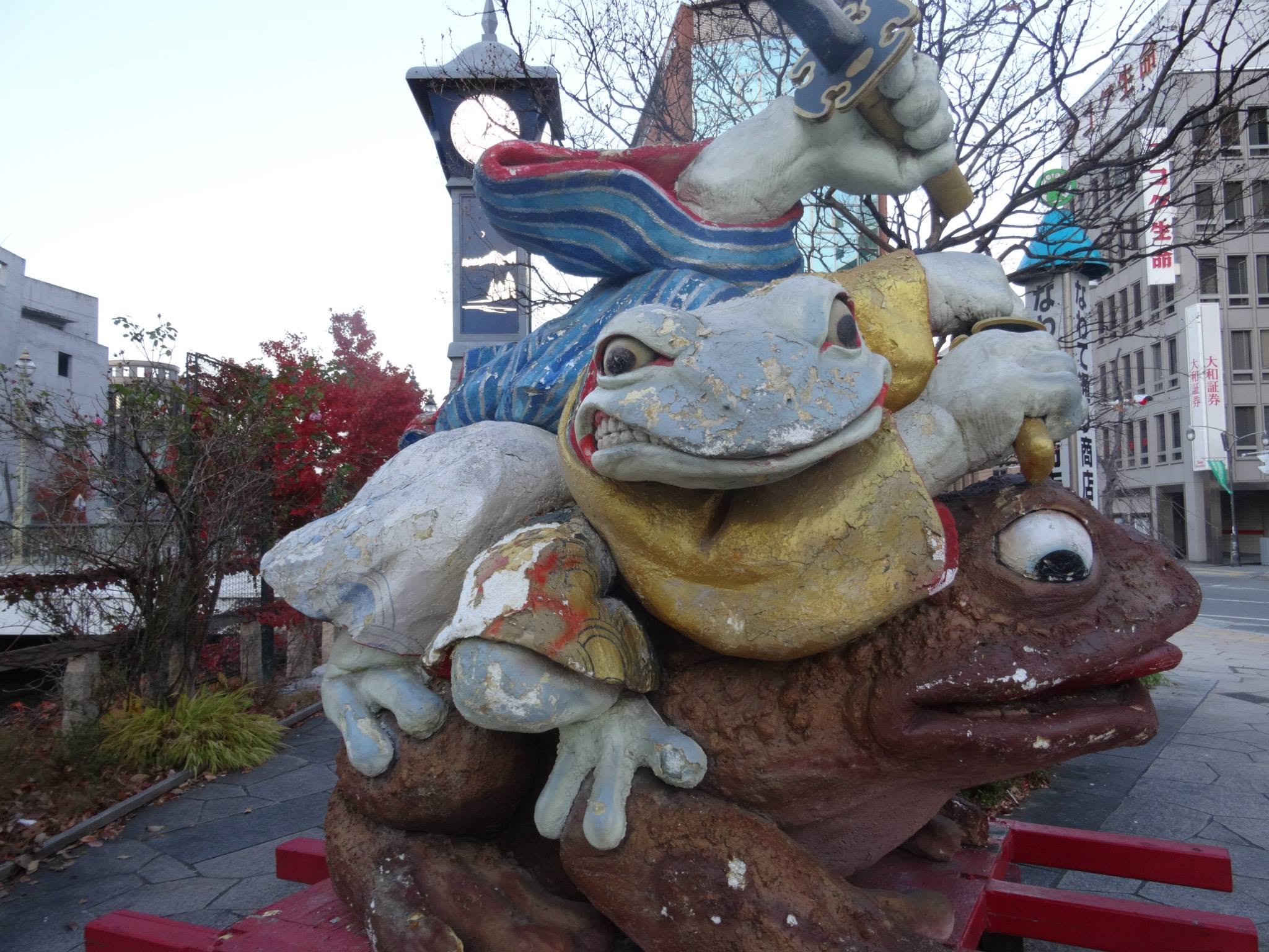 Sculpture colorée de grenouilles dans une rue japonaise.